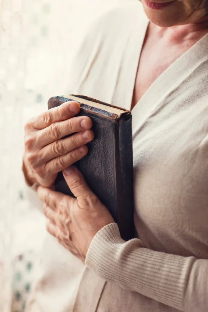 Woman holding the Bible close to her chest